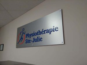 Panneau en alupannel aluminium brossé avec lettres 3D découpé au laser et peintes aux couleurs du logo. Installé avec distanceur et cache-vis | Utilisation : Plaque intérieur à l'accueil
