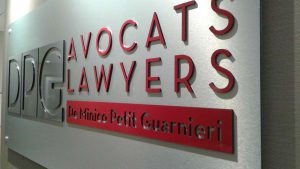 Plaque 1/4" en aluminium brossé avec logo en plexiglass noir recouvert de vinyle autocollant. Installé avec espaceurs et vis èa cap | Utilisation : Logo derrière le bureau d'accueil pour montrer le professionnalisme de la compagnie