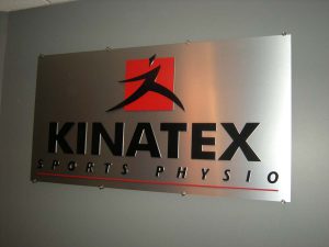 Plaque en alupanel et logo découpé en plexis noir, installé avec fixations fendues | Utilisation : Logo à l'intérieur du commerce